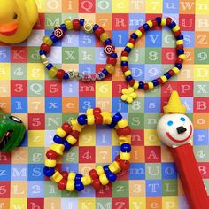 a toy rubber duck, bead necklace and other toys on a colorful background