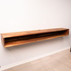 a wooden shelf sitting on top of a white wall