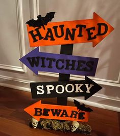 a halloween sign with witches and spooky beware written on it, in front of a door