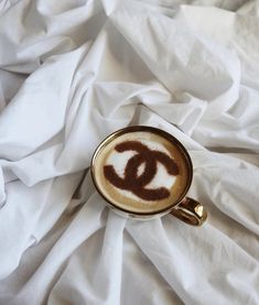 a coffee cup with the word chanel painted in it's foamy liquid