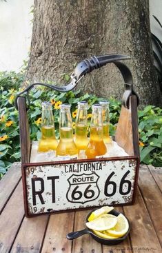 a wooden crate filled with lemonade sitting on top of a table next to a tree