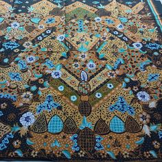 an intricately designed area rug with blue and yellow flowers