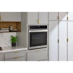 a kitchen with white cabinets and stainless steel appliances, including a built - in microwave