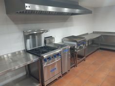 an industrial kitchen with stainless steel appliances and tile flooring