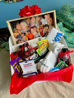 an open gift box filled with personal care items and pictures on the wall behind it