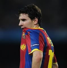 a young man in a soccer uniform looking down at the ground with his hand on his hip