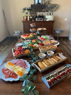 a table filled with lots of food on top of a hard wood floored floor