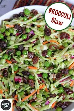 broccoli slaw with carrots and raisins in a white bowl