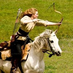 a woman on a horse with a bow and arrow