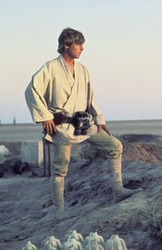 the young man is practicing karate in front of some sand mounds and water bottles on his feet