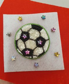 a beaded brooch sitting on top of a piece of paper