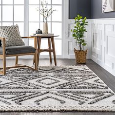 a living room area with a rug, chair and potted plant