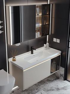 a white sink sitting under a mirror in a bathroom next to a toilet and trash can