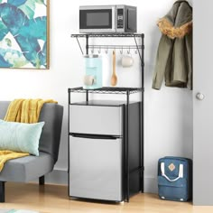 a microwave is on top of a shelf next to a small refrigerator in a living room