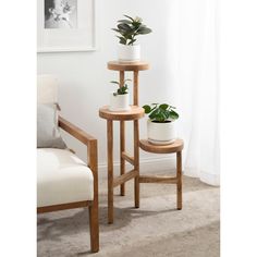 two wooden plant stands sitting next to each other in front of a white chair and window