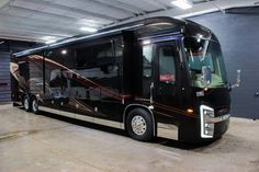 a large black bus parked in a garage