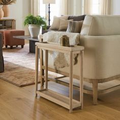 a living room filled with furniture and a wooden table on top of a hard wood floor