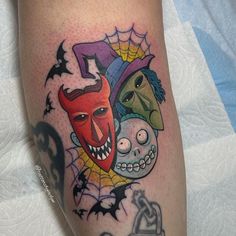 a tattoo on the leg of a person with two faces and bats around them,