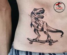 a dinosaur on a skateboard tattoo on the side of a woman's stomach