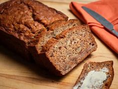 a loaf of bread sitting on top of a wooden cutting board next to a knife