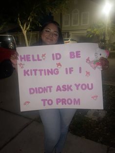 a woman holding a sign that says hell id be kitting if i didn't ask you to prom