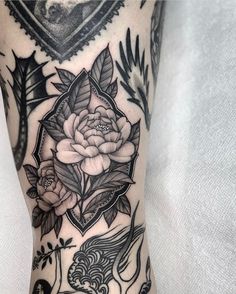 a woman's leg with tattoos and flowers on it