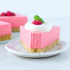 a slice of cheesecake with raspberry filling on a plate next to another piece