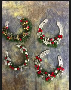 four christmas wreaths are arranged in the shape of horseshoes