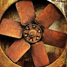 an old, rusty fan with rivets on it's blades is shown