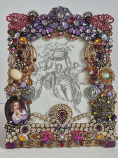 an ornate photo frame is adorned with jewels and other jeweled items, including a portrait of a woman