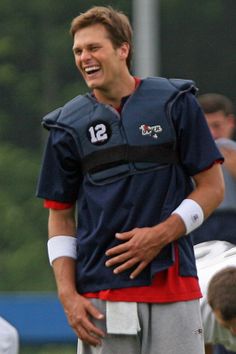 a man laughing while standing on top of a field