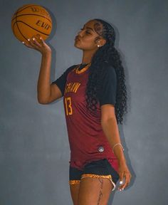 a woman holding a basketball in her right hand