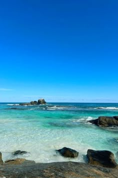 the ocean is crystal blue and clear with rocks