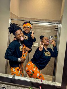 two women taking a selfie in front of a bathroom mirror while wearing matching pajamas