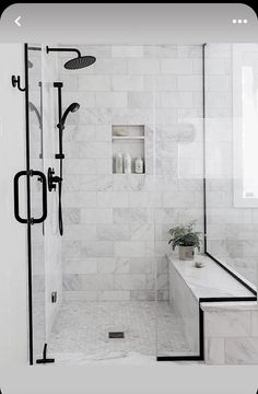 a white bathroom with black fixtures and marble tile flooring, along with a walk in shower