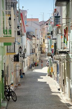 an alley way with several buildings and bicycles parked on the side