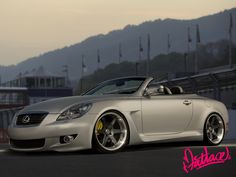 a silver sports car parked in front of a mountain