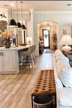 a living room filled with furniture next to a kitchen