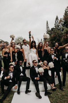 a group of people dressed in black and white posing for a photo with each other