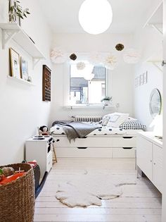 a bedroom with white walls and flooring has a rug on the floor in front of the bed