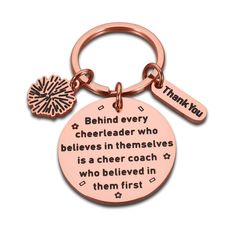 a pink keychain with the words behind it that says,'behind every cheerleader who believe in themselves is a cheer