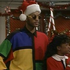 the young man and woman are dressed up in christmas attire, one is wearing a santa hat