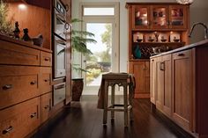 a kitchen with wooden cabinets and an island in front of the door that leads to another room