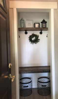 the entry way is decorated with wreaths and baskets on the shelf, along with two lanterns