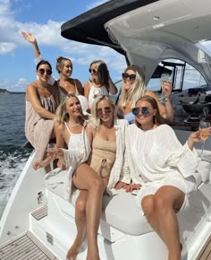 a group of women sitting on the back of a boat holding wine glasses in their hands