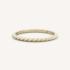 a yellow gold twisted ring on a white background