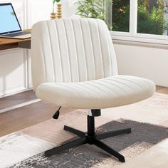 a white office chair sitting in front of a laptop computer