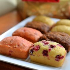 a white plate topped with different types of muffins