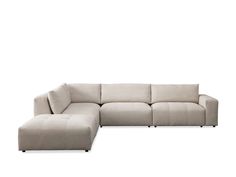 a large sectional couch sitting on top of a white floor next to a footstool