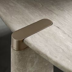 a close up of a metal handle on a marble table top with white and gold veining